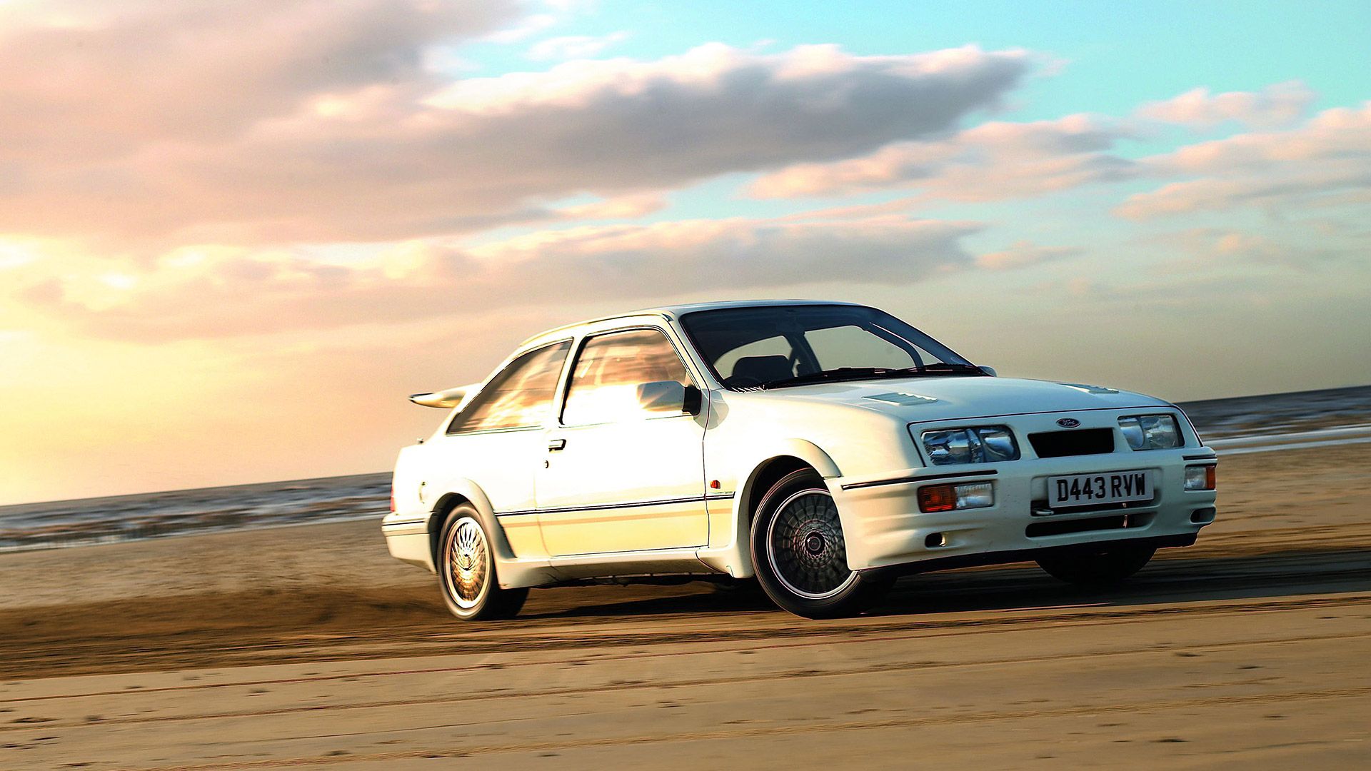 coupe ford xr4 blanca en una playa